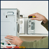 A man unscrewing the back off of a computer.